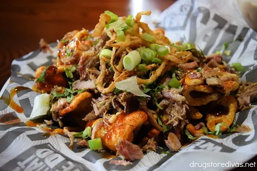 Pulled pork, crispy onion strings, and green onions on top of pork rinds.