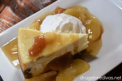 Caramel apple cheesecake and whipped cream on a plate.