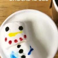 Marshmallow decorated like a snowman in a cup with the words 