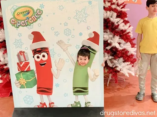 A kid in a Christmas-themed photo cutout at the Crayola Experience in Orlando, Florida.