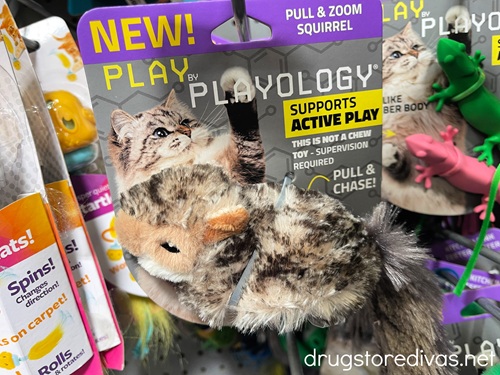 A cat toy shaped like a squirrel in a package on a shelf.