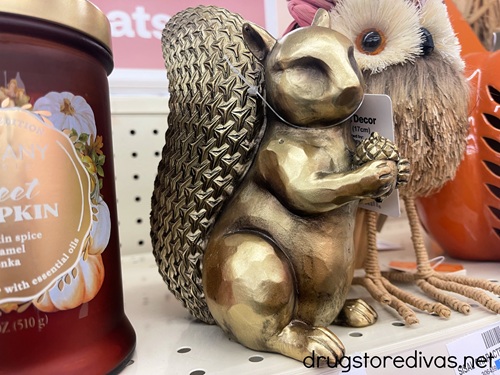 A gold squirrel shaped statue on a shelf.