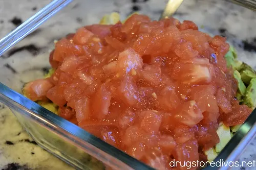 Chopped tomato and avocado in a glass bowl.