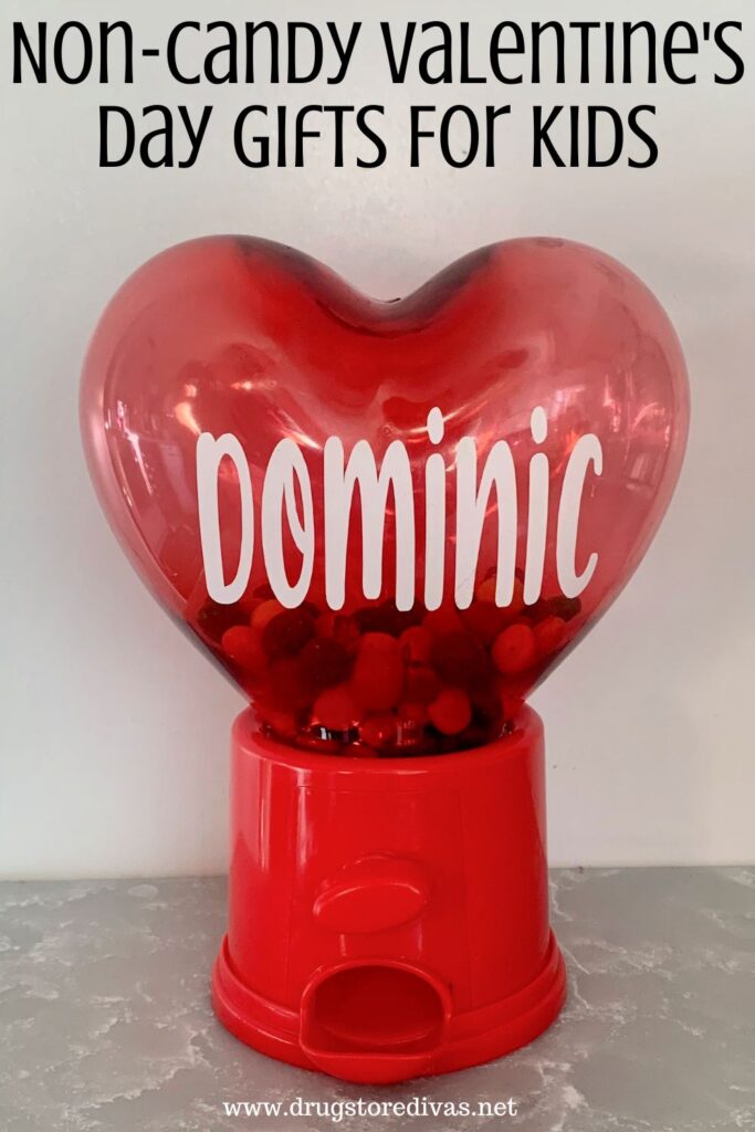 A small gum dispenser with a heart on top and the word DOMINIC on it with the words "Non-Candy Valentine's Day Gifts For Kids" digitally written on top.