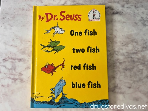 The One Fish Two Fish Red Fish Blue Fish book by Dr Seuss on a table.