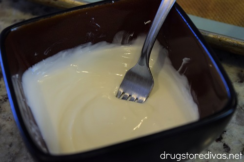 White chocolate melted in a bowl with a fork in it.