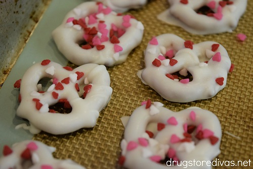 White chocolate covered pretzels with Valentine's Day sprinkles on them.