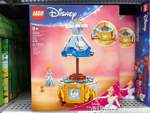 A box containing a Cinderella Dress LEGO set on a shelf in a store.