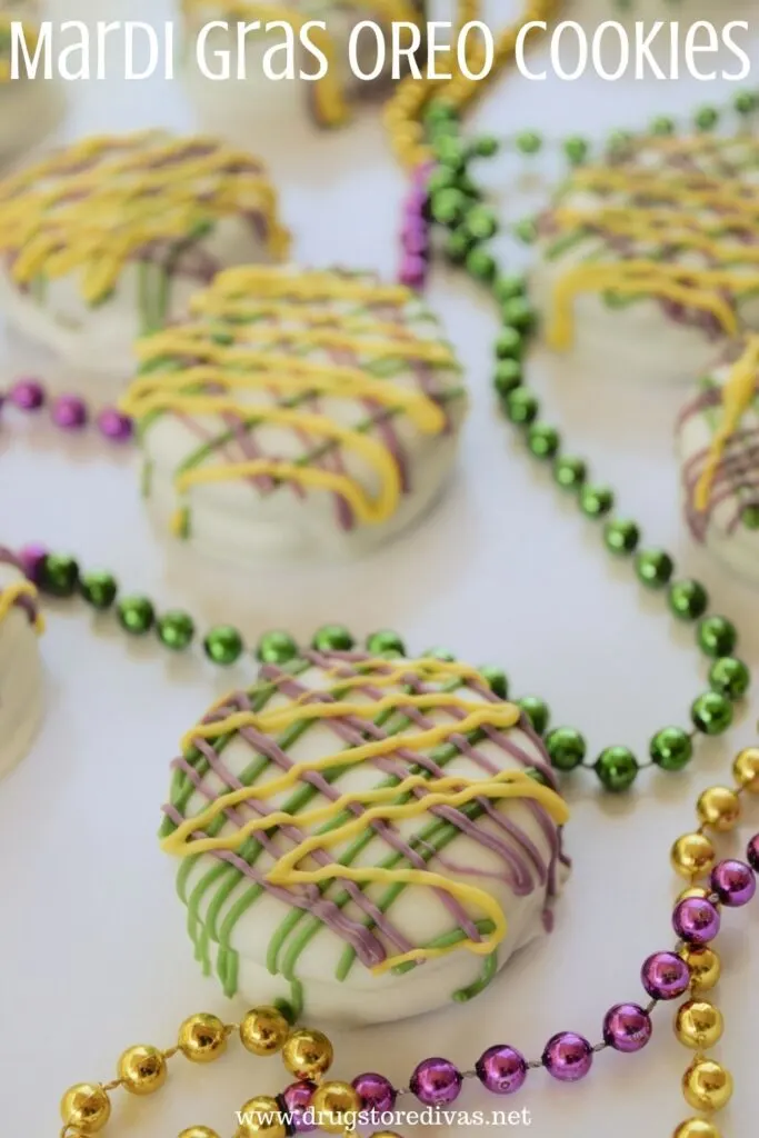 Green, pink, and yellow Oreo cookies with beads on a tray and the words "Mardi Gras Oreo Cookies" digitally written above it.