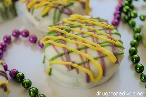 Mardi Gras Oreo Cookies on a plate with Mardi Gras beads.