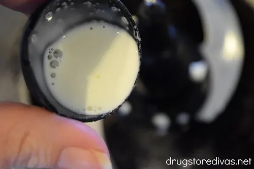 Heavy cream being poured into a food processor.
