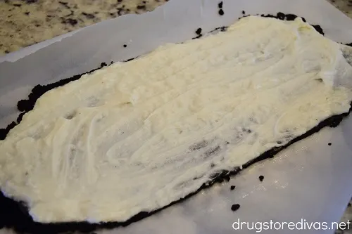A white cream on top of a rectangle of Oreo cookie crumbles.
