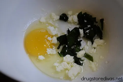 Egg, spinach, and feta cheese in a bowl.