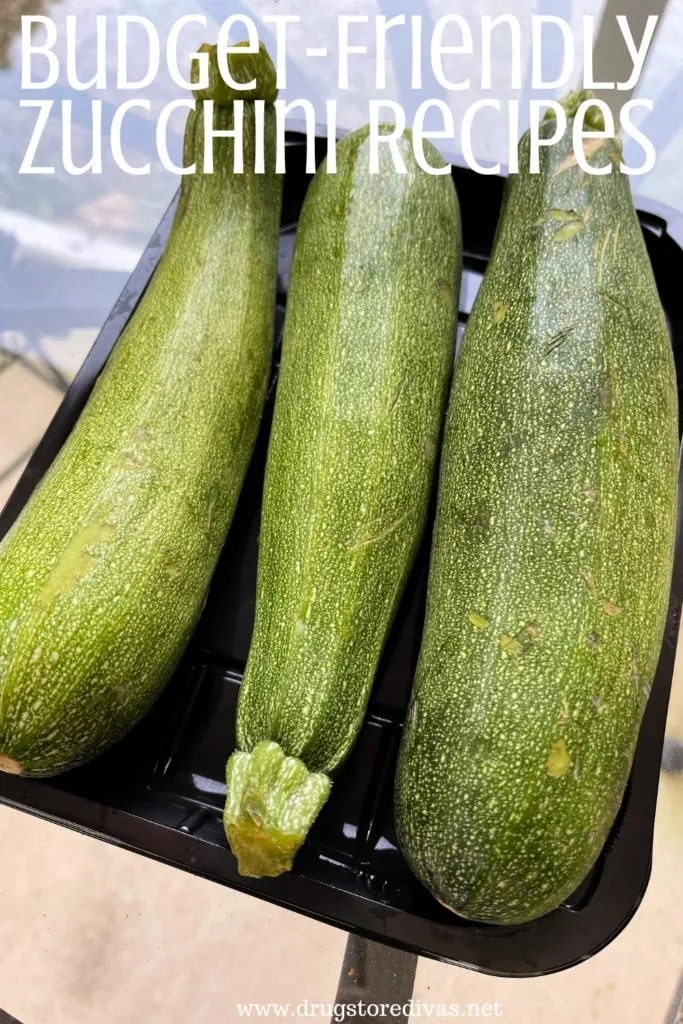 Three zucchini on a table with the words "Budget-Friendly Zucchini Recipes" digitally written on top.