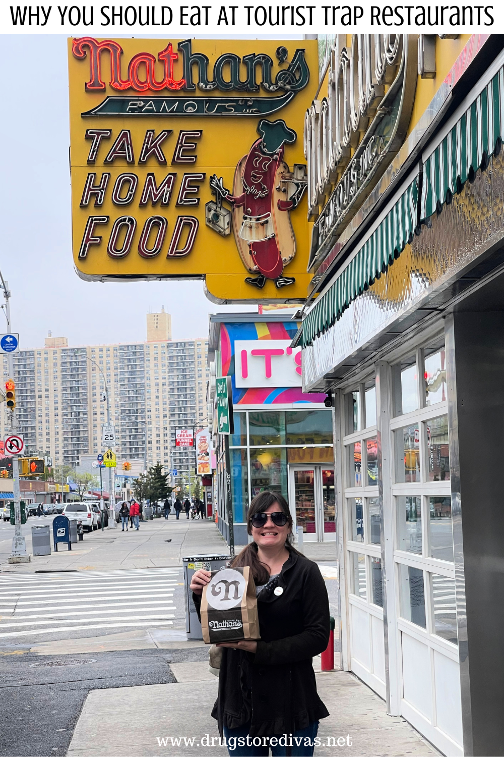 A woman holding a bag in front of the Nathan's Hot Dogs in Coney Island with the words 