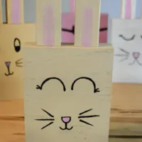Four homemade wooden bunny rabbits with the words 