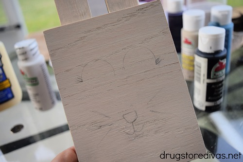 A bunny face drawn on a piece of wood.