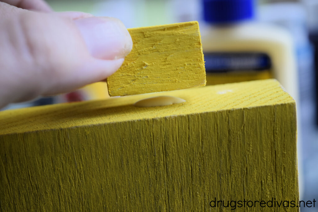 A small yellow block being glued to a larger yellow block.