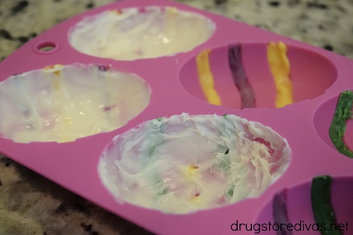Melted white chocolate in a silicone egg mold.