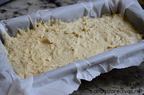 Bread batter in a parchment paper-lined loaf pan.