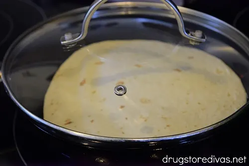 A tortilla in a pan with the lid of top.