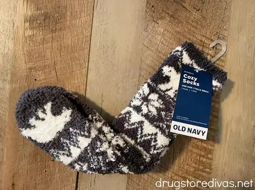 A pair of slipper socks from Old Navy with a tag on them on a piece of wood.