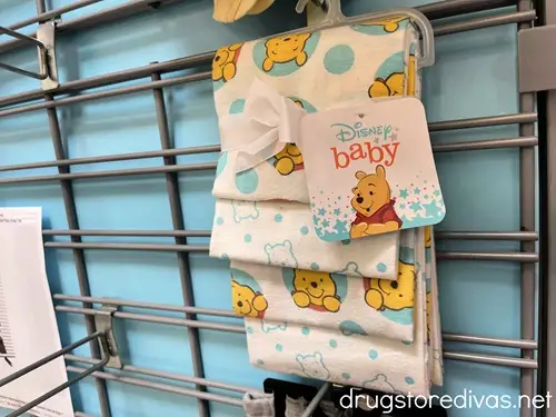 A package of Winnie The Pooh baby washcloths on a peg in a store.