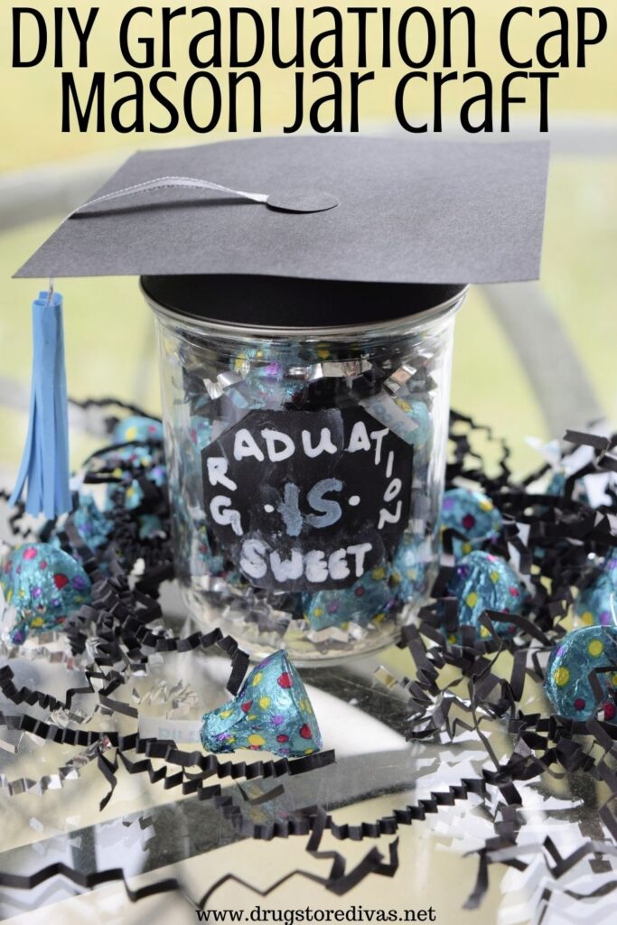 A Mason Jar with a graduation cap filled with and surrounded by candy and paper shred with the words "DIY Graduation Cap Mason Jar Craft" digitally written on top.