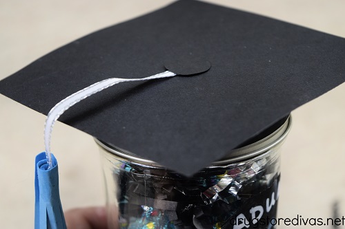 A card stock graduation cap on a mason jar.