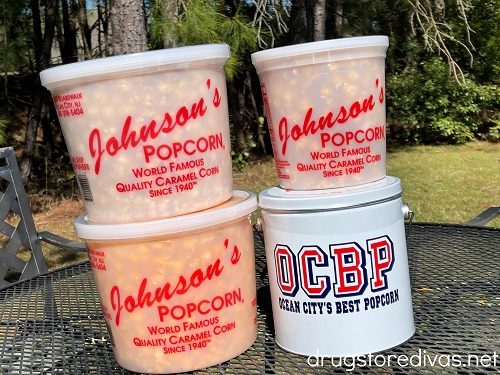 Four containers of Johnson's Popcorn on an outdoor table.