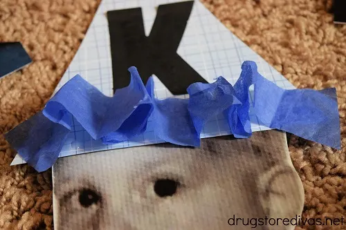 A scrapbook party hat taped to a photo of a face.