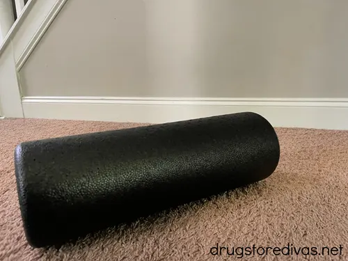 A foam roller on the floor of a living room.