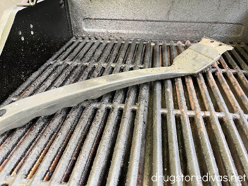 A grill brush laying on a grill.