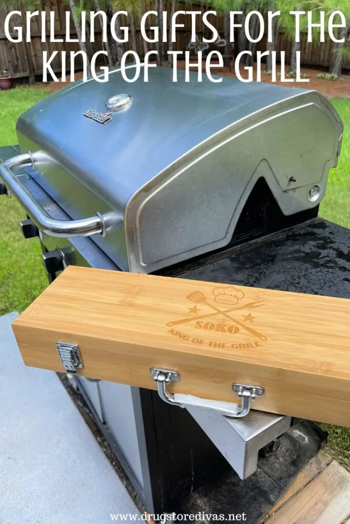 A grill, with a box of grilling tools next to it, and the words "Grilling Gifts For The King Of The Grill" digitally written on top.