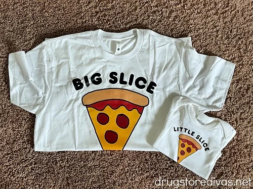A t-shirt with a piece of pizza on it that says "Big Slice" and a onesie with a piece of pizza on it that says "Little Slice".