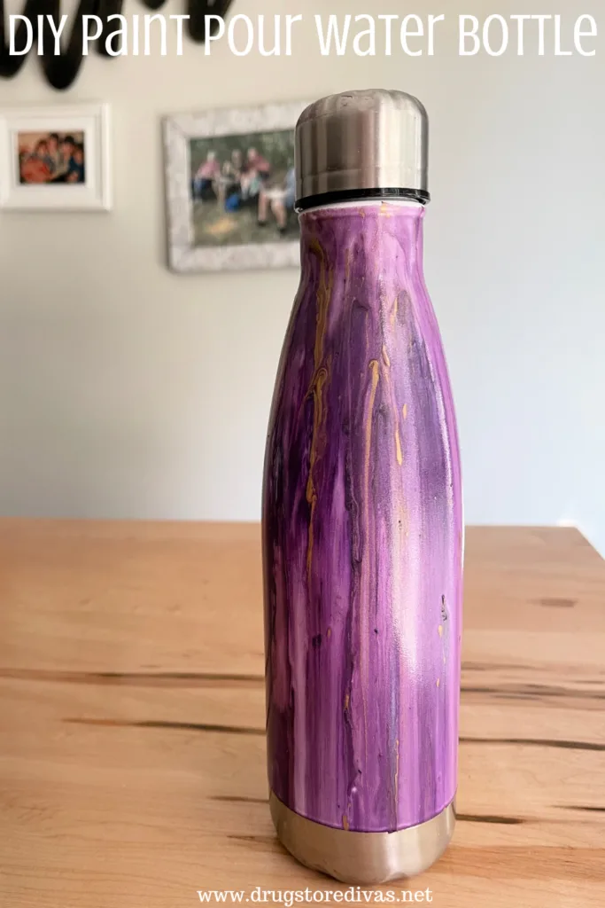 A painted water bottle with the words "DIY Paint Pour Water Bottle" digitally written above it.