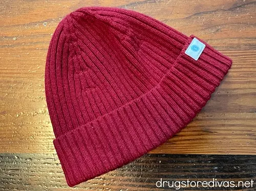 A maroon wool beanie on a wood table.