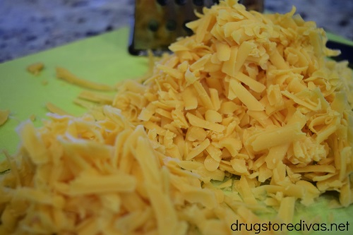 Cheese grated on a cutting board.