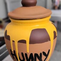 A homemade Winnie the Pooh honey pot replica with the words 