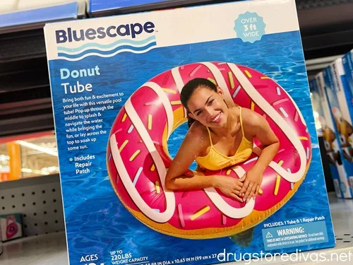 A doughnut shaped pool float in a box on a shelf.
