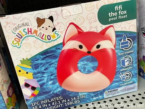 A Squishmallows fox pool float in a box on a shelf in a store.