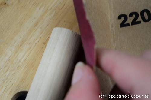 A wooden dowel being sanded.
