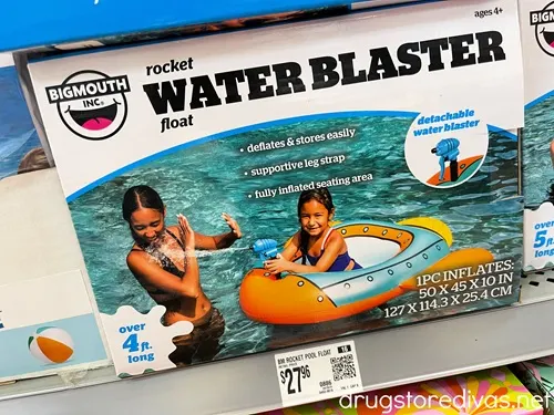 A rocket ship water blaster pool ship in a box on a shelf in a store.