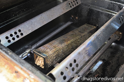 A pellet smoker tube in a propane grill.