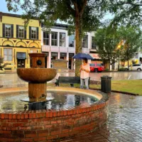 A woman standing in the rain in Abbeville, SC with the words 