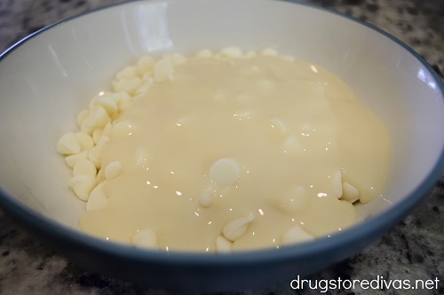 White chocolate chips and condensed milk in a bowl.