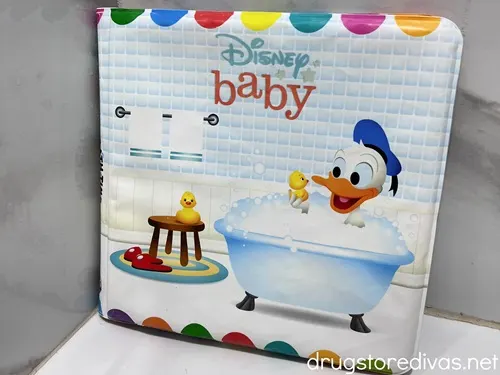 A bath book with Donald Duck on it in the corner of a bath tub.