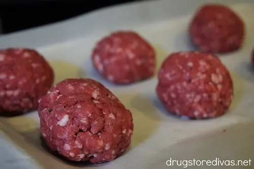 Balls of meat on a cookie sheet.