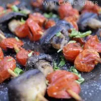 Kabobs with mushroom, tomatoes, and parsley and the words 