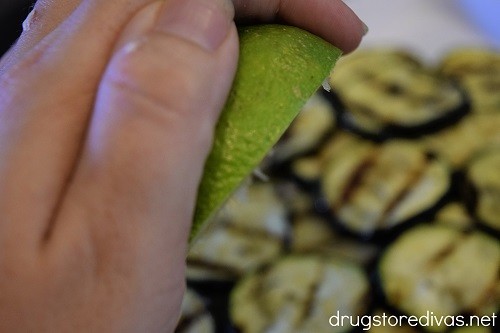 Lime being squeezed on grilled zucchini.